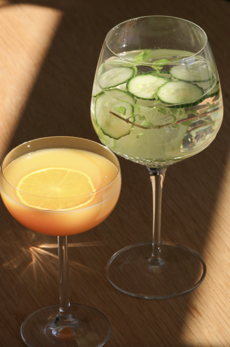 Et glas med juice og et glas med agurk i vand