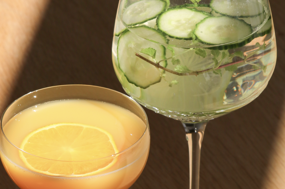 Et glas med juice og et glas med agurk i vand